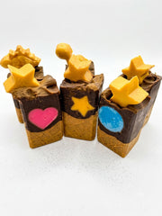 Three Zoapster chocolate cone soap bars in a row, cream and brown layers with yellow star toppers