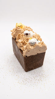 Close up of a salty chocolate whipped soap bar showing the piped swirl and cat topper