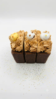 Three salty chocolate whipped soap bars side by side, dark chocolate base with piped cream tops