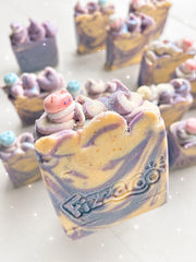 Honey and lavender swirled soap bars in purple and gold, with piped pastel tops